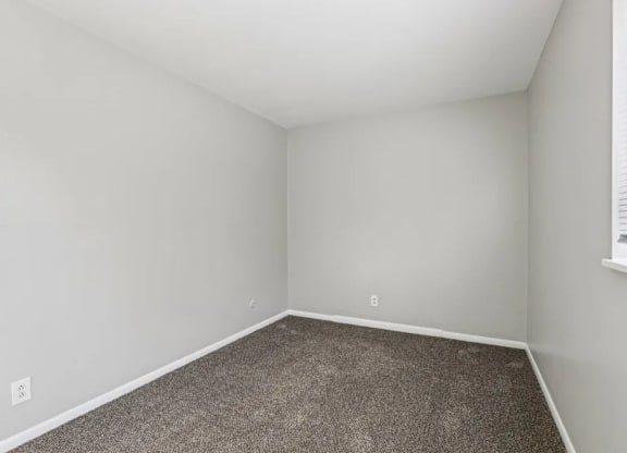 A room with a carpeted floor and white walls.