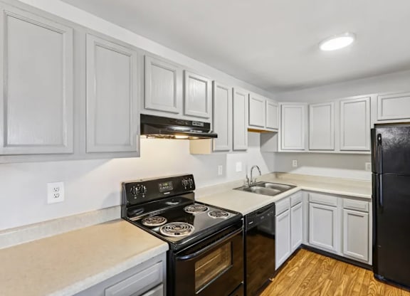 A kitchen with a black stove top oven and white cabinets.