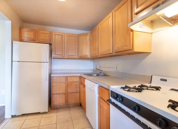 A kitchen with a white refrigerator and a white stove top oven.
