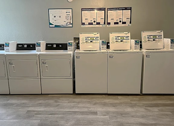 A series of white appliances are lined up against a wall.
