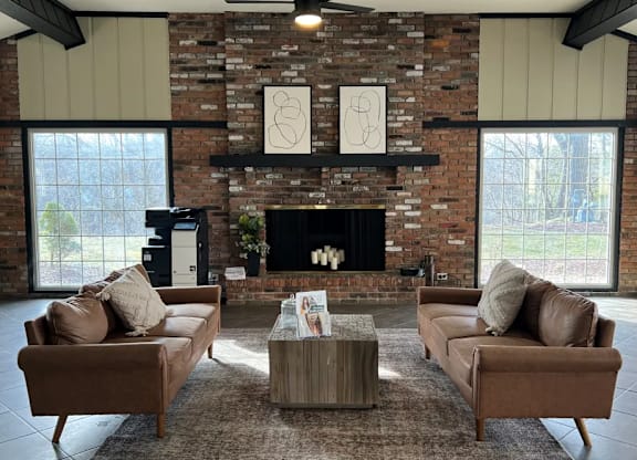 A living room with a fireplace and two couches.