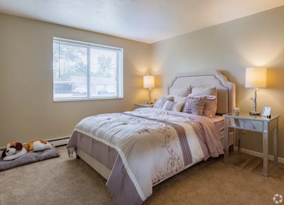 A bedroom with a large bed and a window.