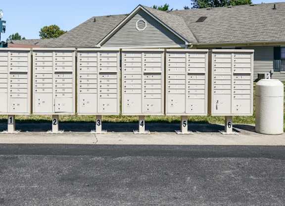 A row of mailboxes are lined up in front of a house.
