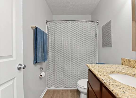 A bathroom with a toilet, sink, and shower.