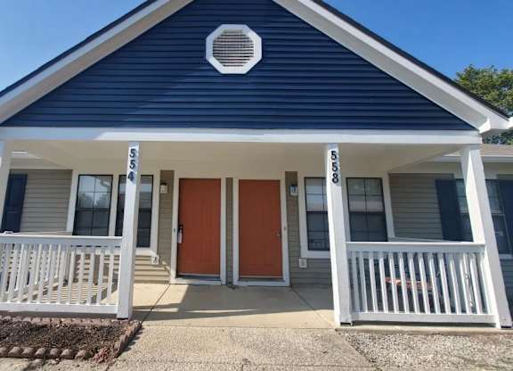 A small house with a blue roof and a white porch.