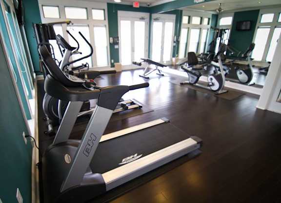 A gym with treadmills and elliptical machines.