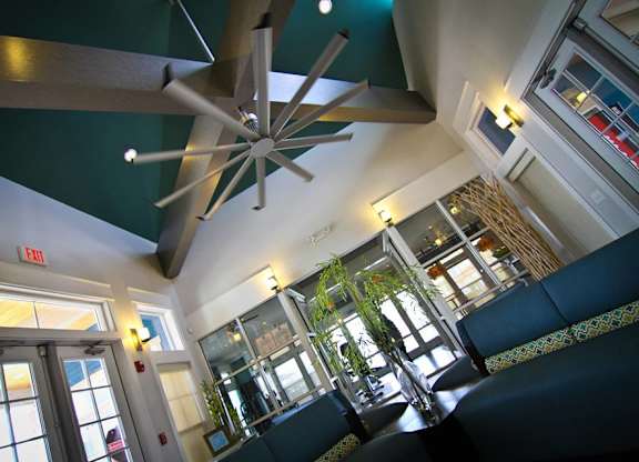 A restaurant with a ceiling fan and a green wall.