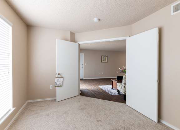 A room with a white door open to a living room.