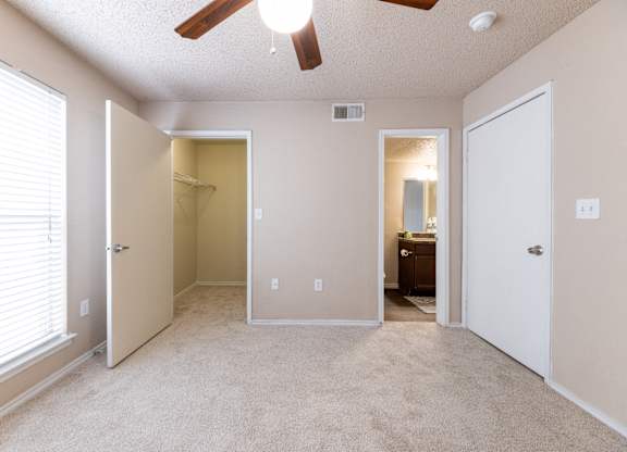 A room with a ceiling fan and a window with blinds.