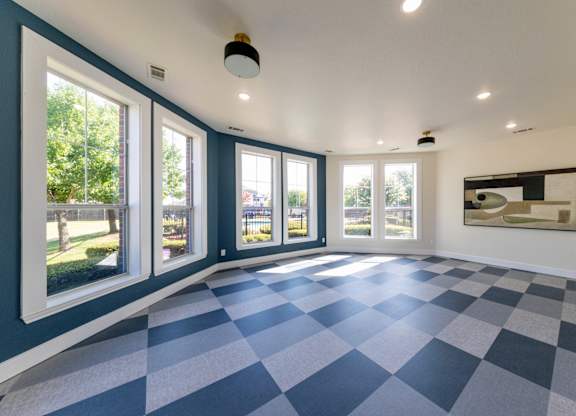 A room with a checkered floor and a painting on the wall.