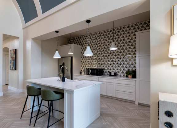 A kitchen with a white counter and green bar stools.