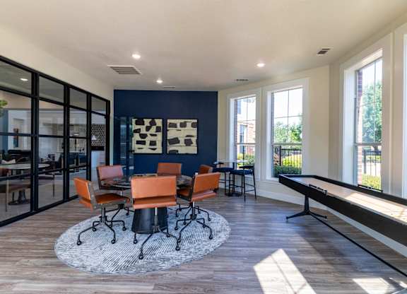 A room with a table and chairs in the middle of the room.