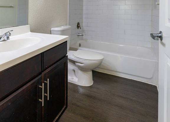A white bathroom with a toilet, sink, and tub.