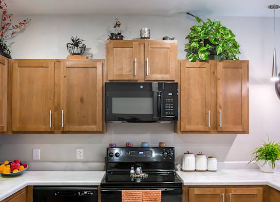 A kitchen with wooden cabinets and a black stove top oven.