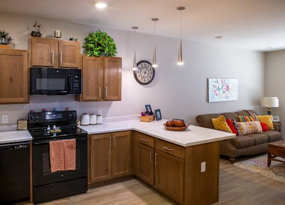 A kitchen with wooden cabinets and a black stove top oven.