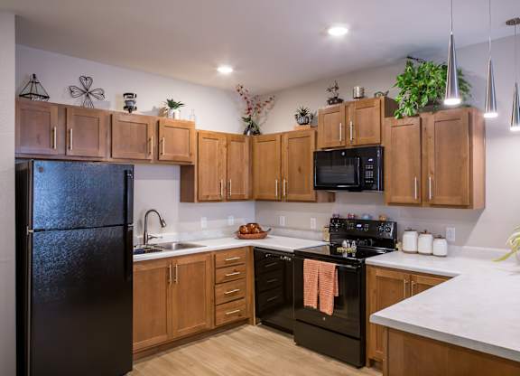 A kitchen with black appliances and wooden cabinets.