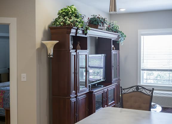 A kitchen with a wooden cabinet and a white counter.