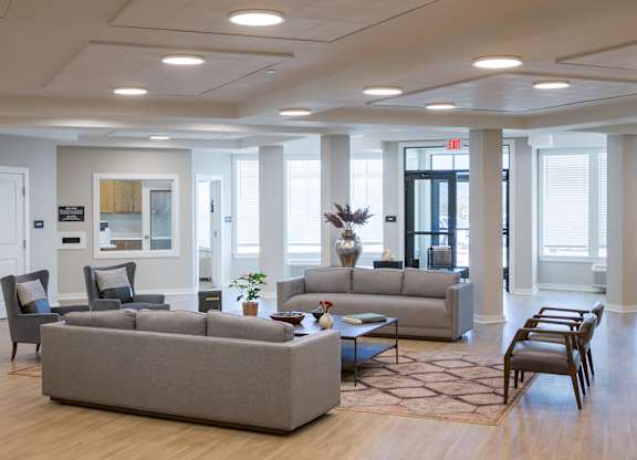 A spacious living room with a grey sofa set and a coffee table.