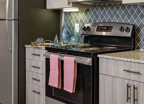 A kitchen with a black oven and a black fridge.