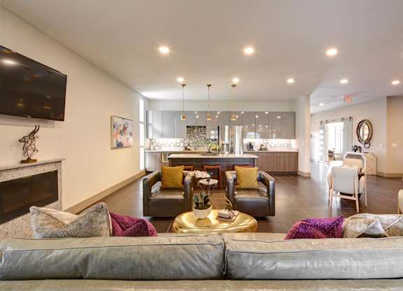 A living room with a grey sofa and a fireplace.