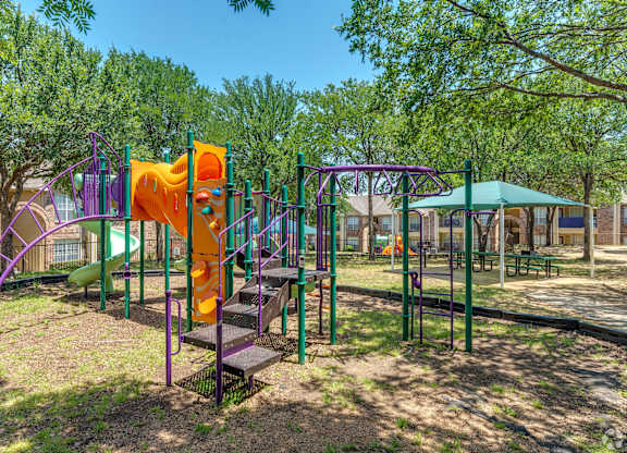 A playground with a purple and orange slide.