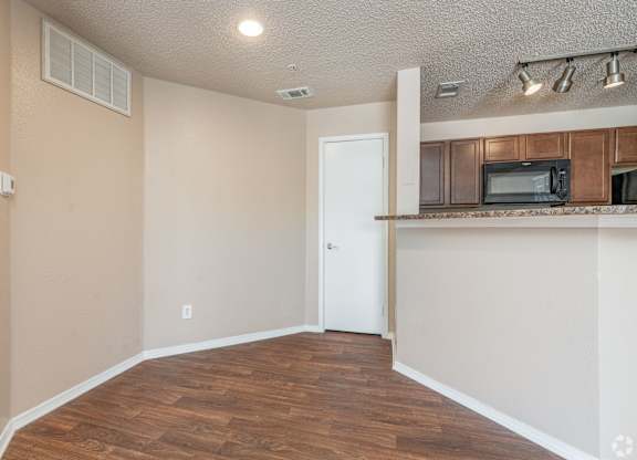 A room with a white door and a brown floor.