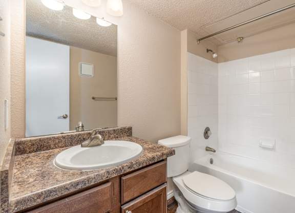A bathroom with a sink, toilet, and bathtub.