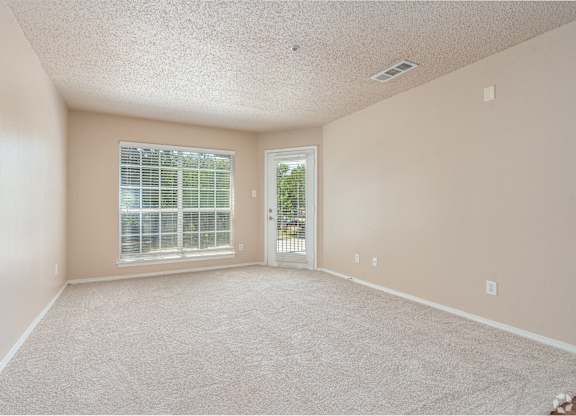 Empty room with carpeted floor and a window with blinds.