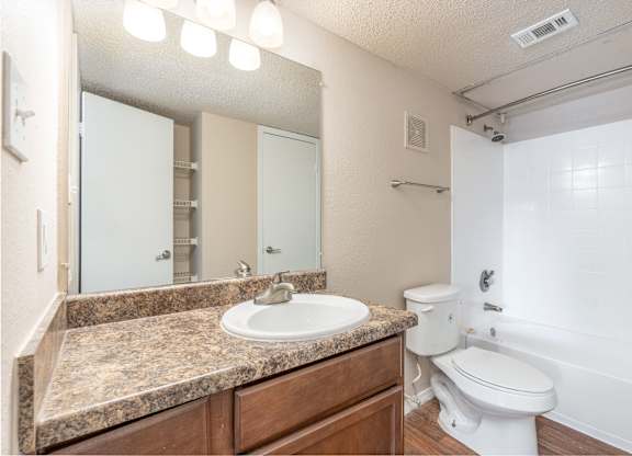 A bathroom with a sink, toilet, and bathtub.