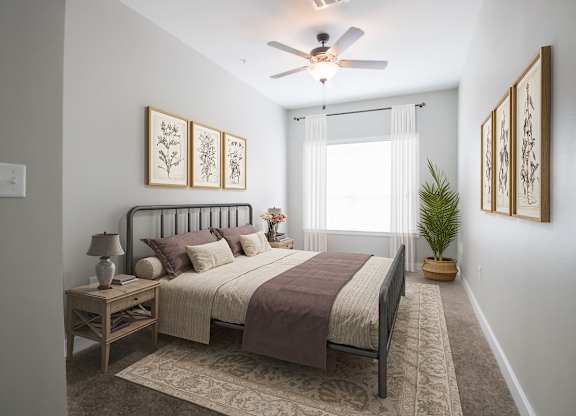 A bedroom with a bed, nightstand, and a ceiling fan.