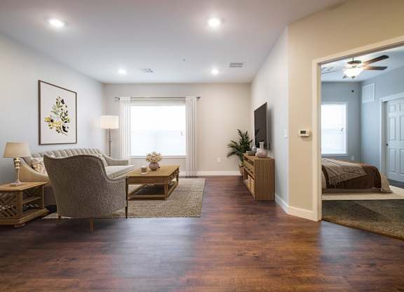 A living room with a chair, a table, and a painting on the wall.