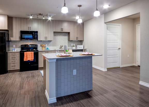 A kitchen with a black oven and a black microwave.