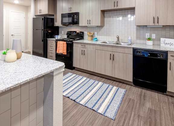 A kitchen with a black oven and a white counter.