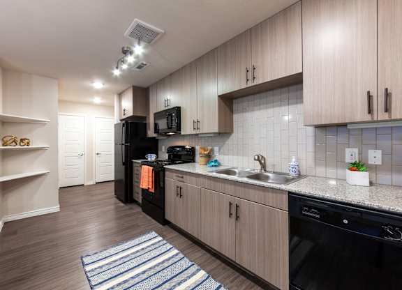 A kitchen with wooden cabinets and black appliances.