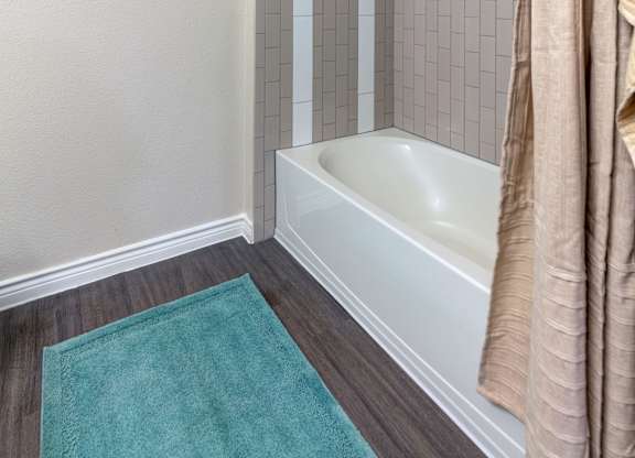 A white bathtub with a shower curtain in a bathroom.