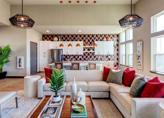A modern living room with a large sofa, a coffee table, and a potted plant.