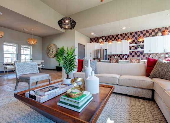 A living room with a white couch, a coffee table, and a potted plant.