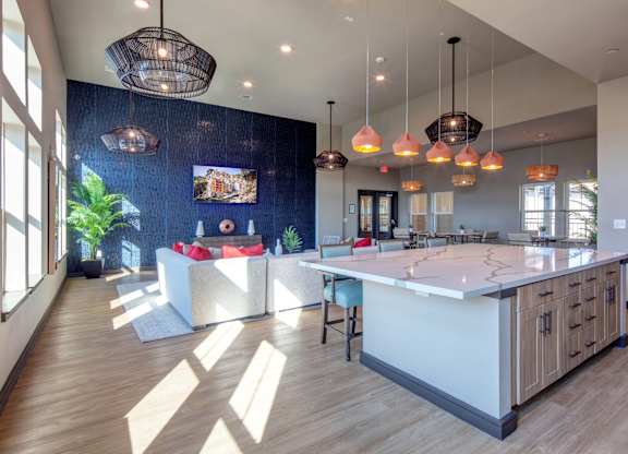 A modern kitchen with a large island and pendant lights.