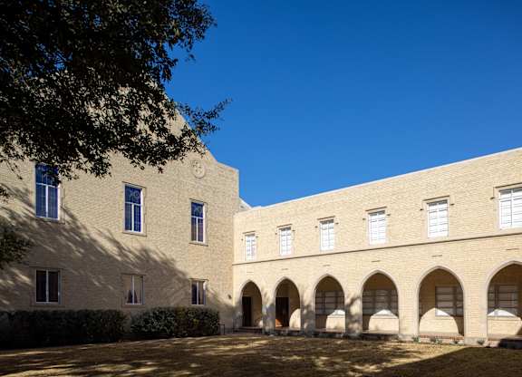 A building with arches and windows under a blue sky.