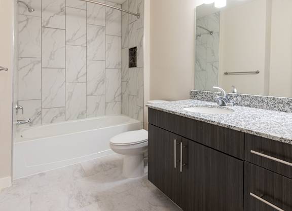 A bathroom with a marble tile floor and a white toilet.