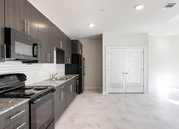 A modern kitchen with dark wood cabinets and a white countertop.