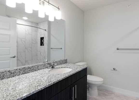 A bathroom with a marble countertop and a white toilet.