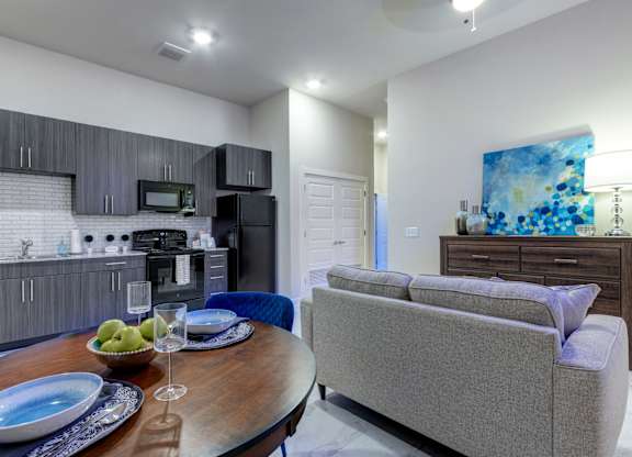 A modern kitchen with a dining table set for two.