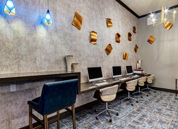 A room with a desk, chairs, and computers.