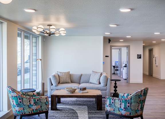 A living room with a couch, two chairs, and a coffee table.
