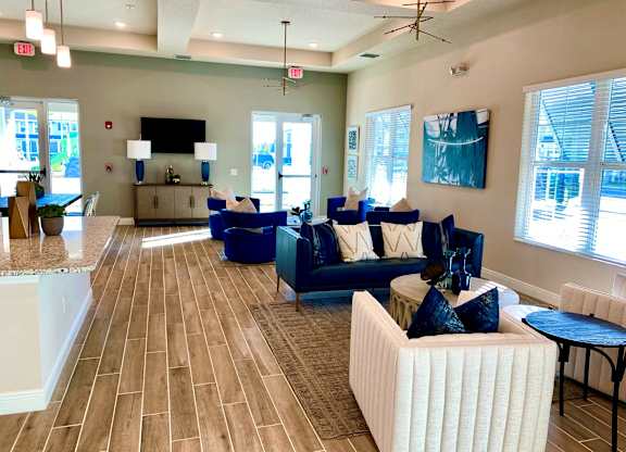 A living room with a white couch and blue chairs.