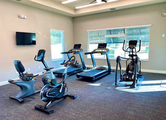 A room with a television and exercise equipment.