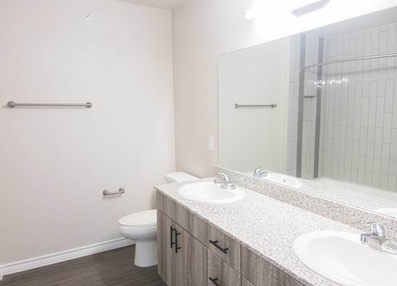 A bathroom with a toilet, sink, and mirror.