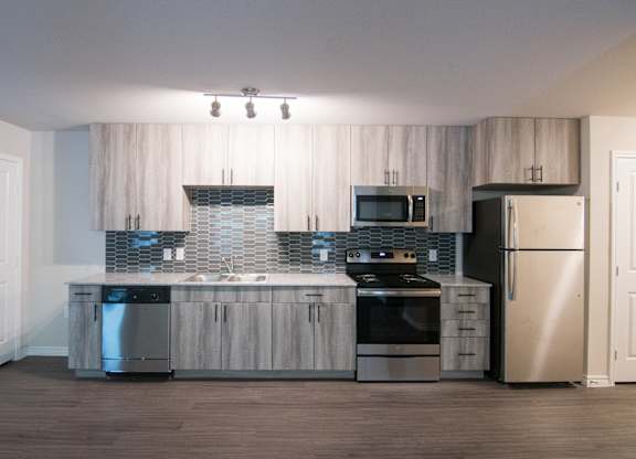 A modern kitchen with stainless steel appliances and wooden cabinets.
