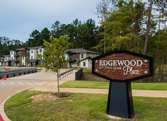 A sign for Edgewood Clinic Drive stands in front of a building.